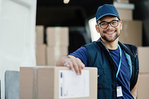 Young worker unloading boxes from a delivery van