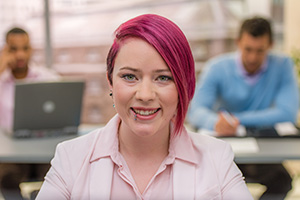 Portrait of businesswoman smiling in office, close-up.